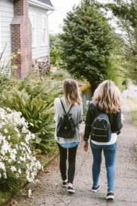 Teens walking outside near flowers and green trees. If your teen is struggling with anxiety, depression, or stress, then it may be time to begin teen counseling in southlake, tx. We also provide online counseling for teens in Texas, if online therapy for teens fits better. Call now!
