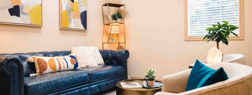 A living room featuring a blue leather couch and a matching blue chair, creating a cohesive and stylish seating area
